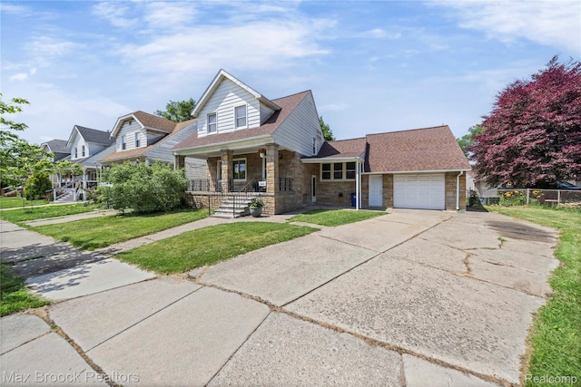 643 Spencer St, Ferndale, MI 48220 - view of front facade with covered porch, stone siding, driveway, a garage, and roof with shingles