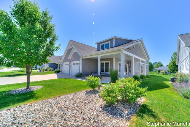 675 Terrace Point Dr, Muskegon, MI 49440 - view of front of home featuring an attached garage, driveway, a front lawn, a porch, and a shingled roof