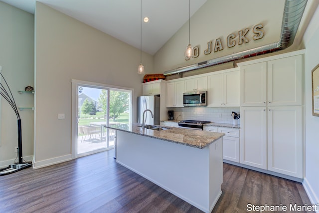 675 Terrace Point Dr, Muskegon, MI 49440 - kitchen with stainless steel microwave, high vaulted ceiling, freestanding refrigerator, dark wood finished floors, and an island with sink