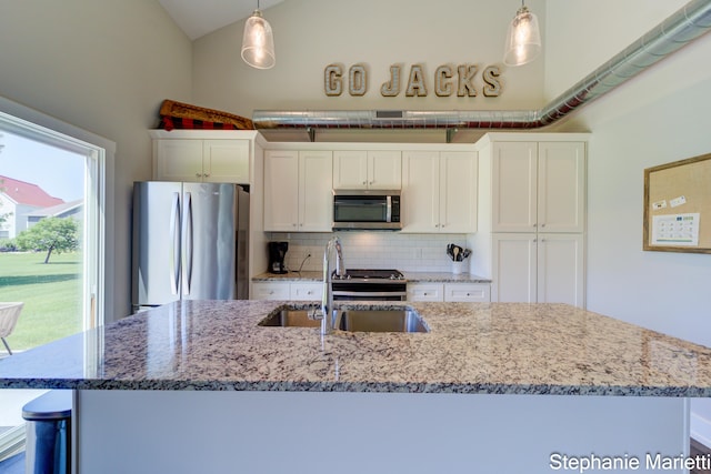 675 Terrace Point Dr, Muskegon, MI 49440 - kitchen with stainless steel appliances, backsplash, white cabinetry, pendant lighting, and vaulted ceiling