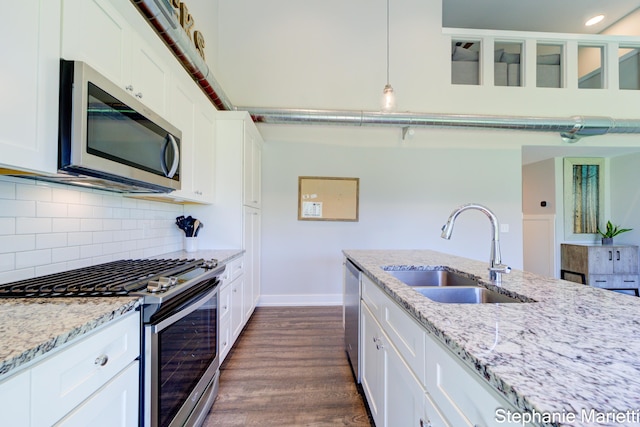 675 Terrace Point Dr, Muskegon, MI 49440 - kitchen featuring stainless steel appliances, backsplash, dark wood-type flooring, white cabinetry, and light stone countertops