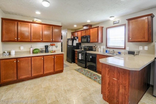 491 Harrison Dr, Davison, MI 48423 - kitchen with black appliances, light countertops, a peninsula, a textured ceiling, and brown cabinetry