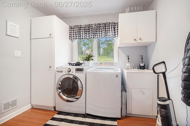 4469 Tanbark St, Bloomfield Hills, MI 48302 - laundry area featuring cabinet space, washer and clothes dryer, and light wood-style floors