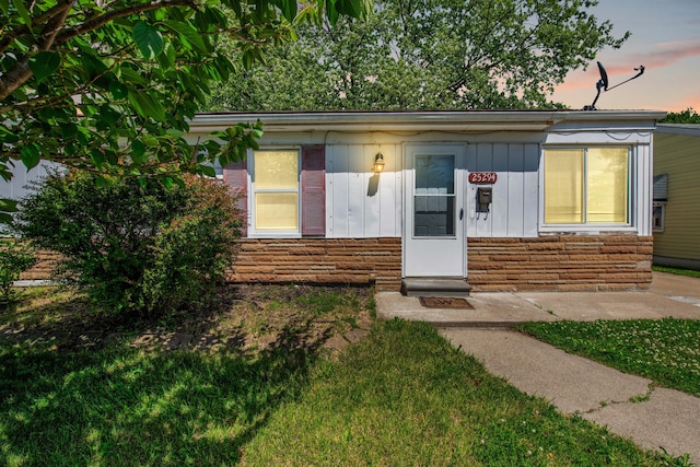 25294 Wiseman St, Roseville, MI 48066 - view of front of house featuring board and batten siding, stone siding, and a yard