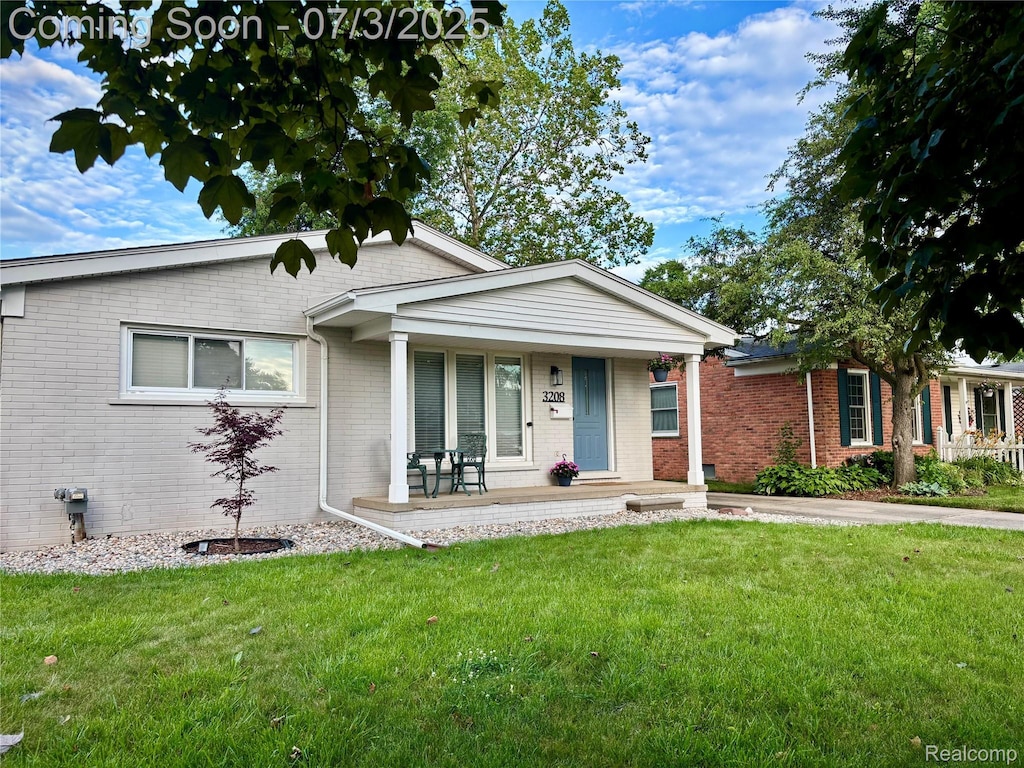 3208 Clawson Ave, Royal Oak, MI 48073 - view of front of home featuring brick siding, covered porch, and a front yard