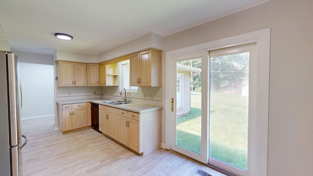 7106 Partridge Dr, Flushing, MI 48433 - kitchen featuring freestanding refrigerator, light brown cabinetry, light countertops, black dishwasher, and plenty of natural light