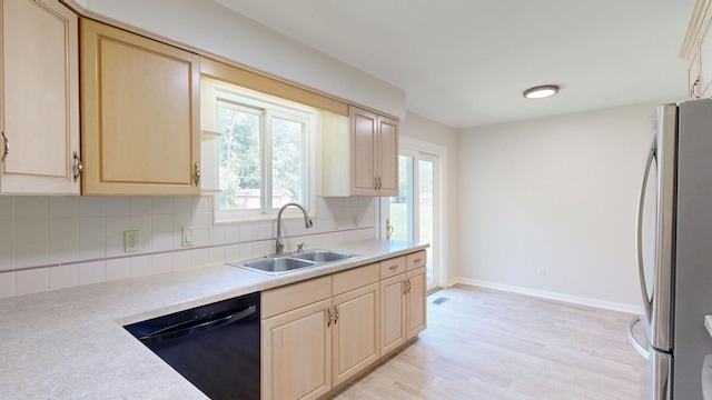 7106 Partridge Dr, Flushing, MI 48433 - kitchen with freestanding refrigerator, black dishwasher, light countertops, and backsplash