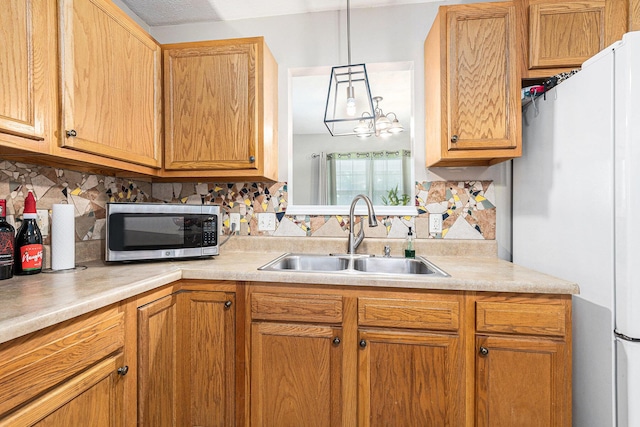 1449 Marquette St SW, Wyoming, MI 49509 - kitchen with stainless steel microwave, freestanding refrigerator, light countertops, decorative backsplash, and pendant lighting