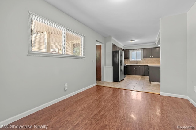 3196 Red Barn Rd, Flint, MI 48507 - kitchen with stainless steel refrigerator with ice dispenser, light countertops, light wood-style floors, and backsplash