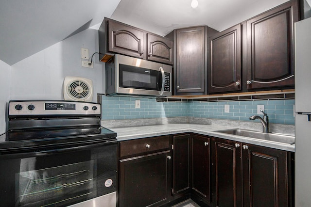 814 12th St NW, Grand Rapids, MI 49504 - kitchen featuring appliances with stainless steel finishes, light countertops, decorative backsplash, lofted ceiling, and dark brown cabinets