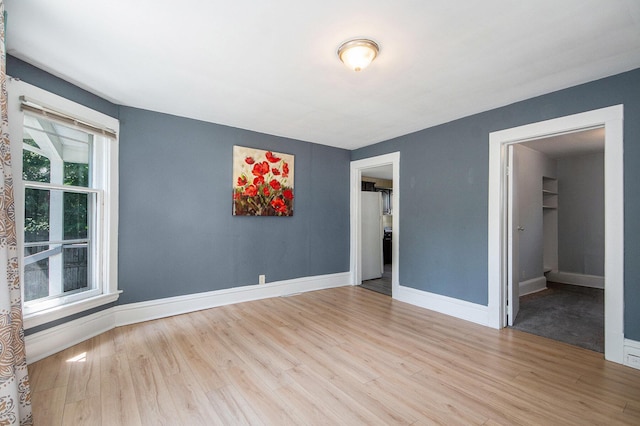 814 12th St NW, Grand Rapids, MI 49504 - unfurnished bedroom with wood finished floors and a walk in closet
