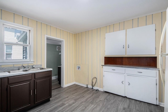 814 12th St NW, Grand Rapids, MI 49504 - kitchen with light wood-style floors, white cabinetry, dark brown cabinets, freestanding refrigerator, and light countertops