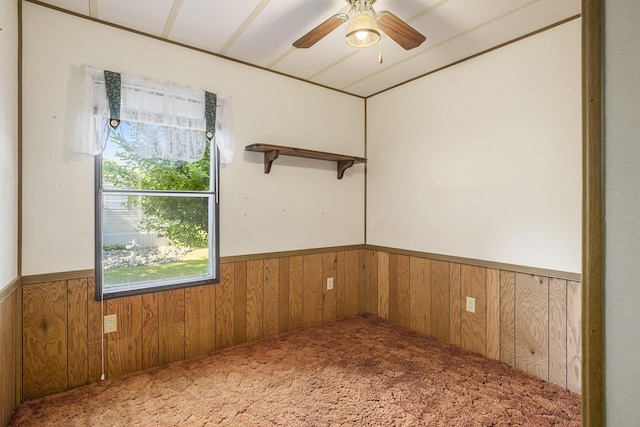 12963 E Englewright Dr, Sand Lake, MI 49343 - carpeted empty room with a wainscoted wall, wood walls, and ceiling fan