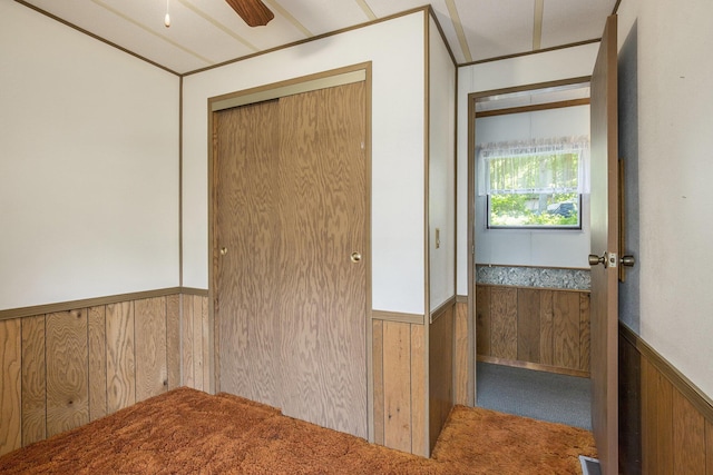 12963 E Englewright Dr, Sand Lake, MI 49343 - carpeted empty room featuring wainscoting, wooden walls, and ceiling fan