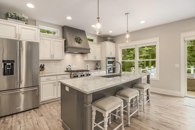 3479 Jeffrey Spur, Hamilton, MI 49419 - kitchen with stainless steel appliances, custom exhaust hood, light wood-style floors, decorative backsplash, and white cabinetry