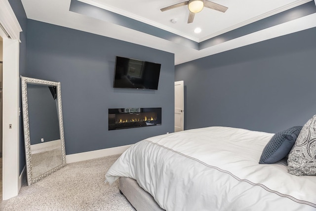 3479 Jeffrey Spur, Hamilton, MI 49419 - bedroom with a tray ceiling, carpet flooring, a glass covered fireplace, crown molding, and ceiling fan