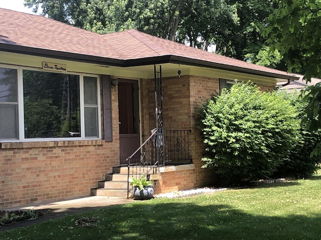1113 Nichols Rd, Kalamazoo, MI 49006 - entrance to property with brick siding, a lawn, and a shingled roof