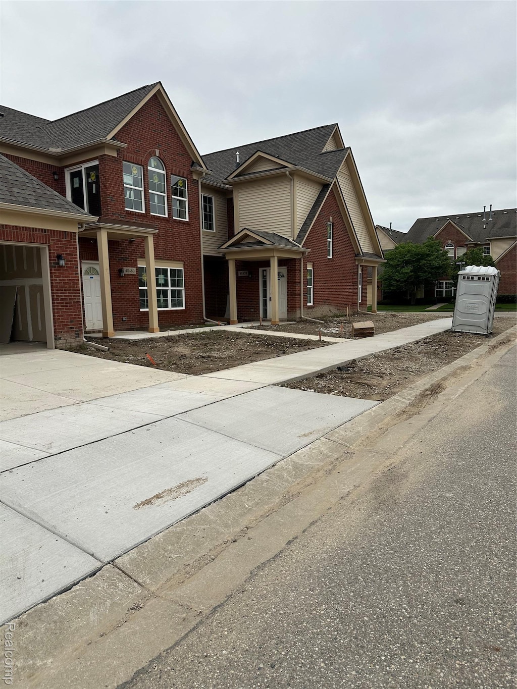48498 Bridge Way Unit 561, Canton, MI 48188 - traditional-style house featuring brick siding, driveway, and an attached garage