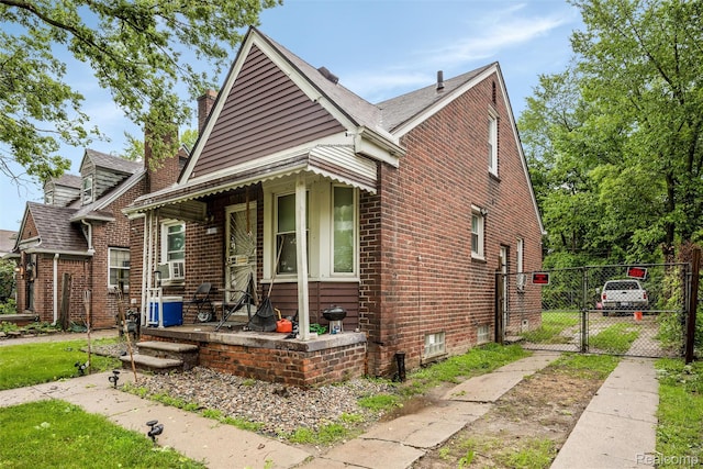 11358 Asbury Park, Detroit, MI 48205 - bungalow-style home with a gate, brick siding, a chimney, and cooling unit