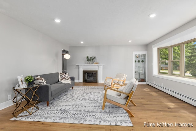 630 Westview Ave NW, Grand Rapids, MI 49504 - living room featuring wood finished floors, a glass covered fireplace, recessed lighting, and baseboard heating