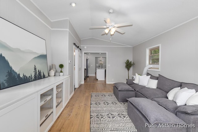 630 Westview Ave NW, Grand Rapids, MI 49504 - living area featuring light wood-style floors, ceiling fan, vaulted ceiling, a barn door, and ornamental molding