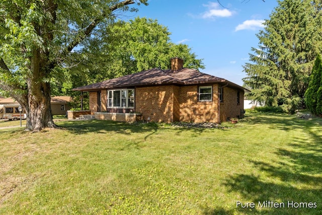 630 Westview Ave NW, Grand Rapids, MI 49504 - view of side of home featuring a chimney, a lawn, and brick siding