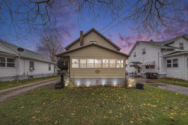 317 E Argyle St, Jackson, MI 49202 - property exterior at dusk with a chimney and cooling unit