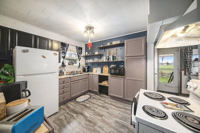 317 E Argyle St, Jackson, MI 49202 - kitchen featuring white appliances, gray cabinets, open shelves, ventilation hood, and light countertops