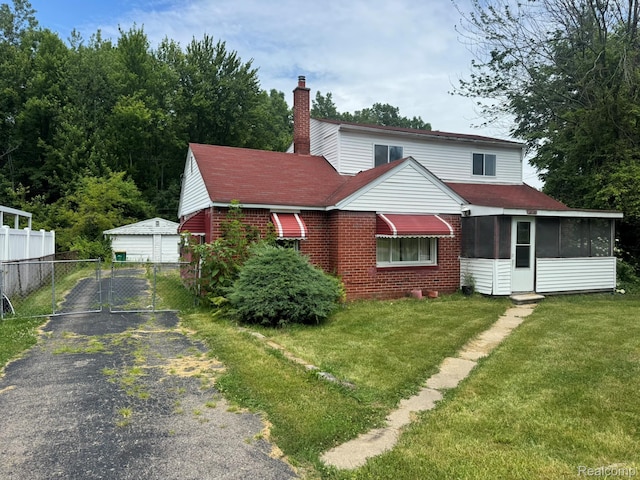 35740 Beverly Rd, Detroit, MI 48174 - view of front facade with a chimney, a sunroom, brick siding, and an outbuilding