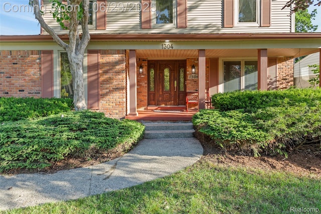 1304 Player Dr, Troy, MI 48085 - view of exterior entry featuring brick siding and a porch