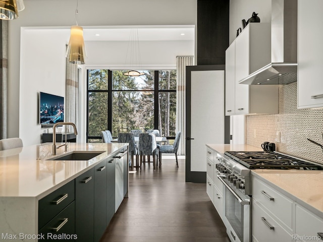 4890 Charing Cross Rd, Bloomfield Hills, MI 48304 - kitchen with wall chimney range hood, high end stove, tasteful backsplash, dark wood-style flooring, and white cabinetry
