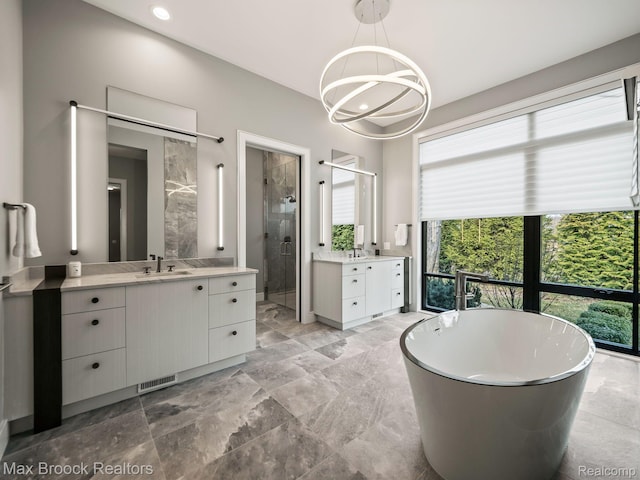 4890 Charing Cross Rd, Bloomfield Hills, MI 48304 - bathroom with a stall shower, two vanities, a freestanding tub, a chandelier, and recessed lighting