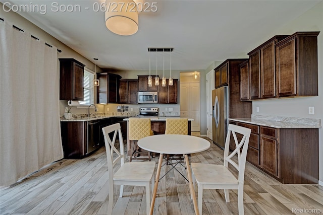 28545 Cottage Ln, New Hudson, MI 48165 - kitchen featuring appliances with stainless steel finishes, light wood finished floors, and dark brown cabinets