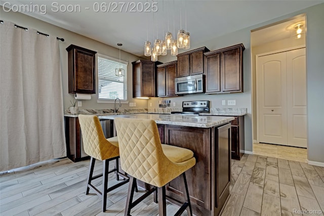 28545 Cottage Ln, New Hudson, MI 48165 - kitchen with appliances with stainless steel finishes, light wood-style floors, dark brown cabinets, and a center island
