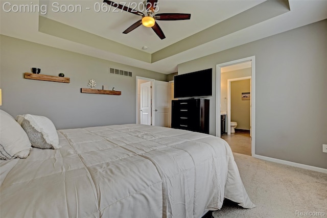 28545 Cottage Ln, New Hudson, MI 48165 - bedroom with a raised ceiling, light colored carpet, connected bathroom, and a ceiling fan