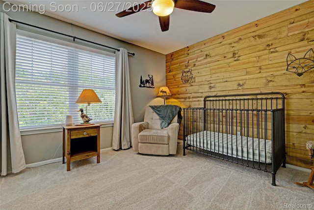 28545 Cottage Ln, New Hudson, MI 48165 - bedroom featuring carpet, wooden walls, a ceiling fan, and a nursery area