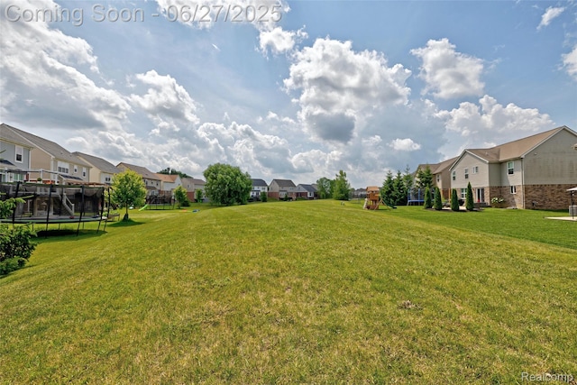 28545 Cottage Ln, New Hudson, MI 48165 - view of green lawn featuring a residential view and a trampoline