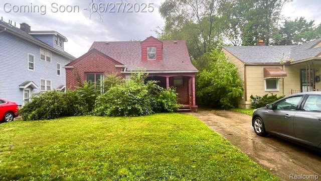 12857 Robson St, Detroit, MI 48227 - view of front of property with a front yard, brick siding, and a porch