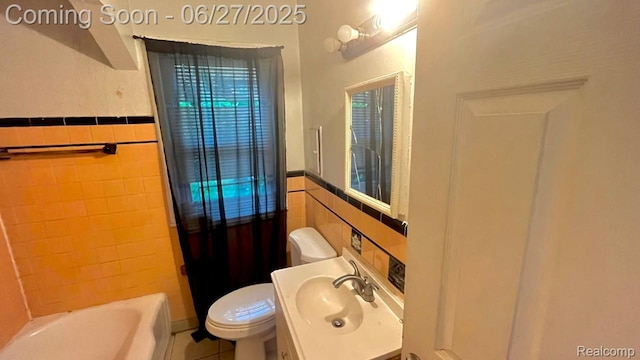 12857 Robson St, Detroit, MI 48227 - full bathroom with tile walls, a tub to relax in, vanity, a wainscoted wall, and tile patterned flooring