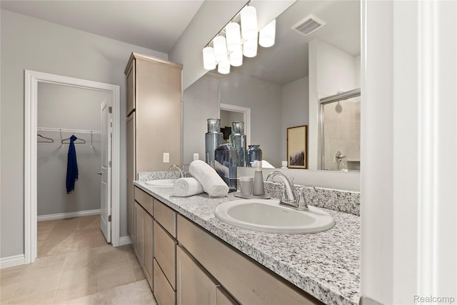 2270 Chase Dr Unit 112, Howell, MI 48855 - full bathroom featuring double vanity, a spacious closet, tile patterned flooring, and a shower