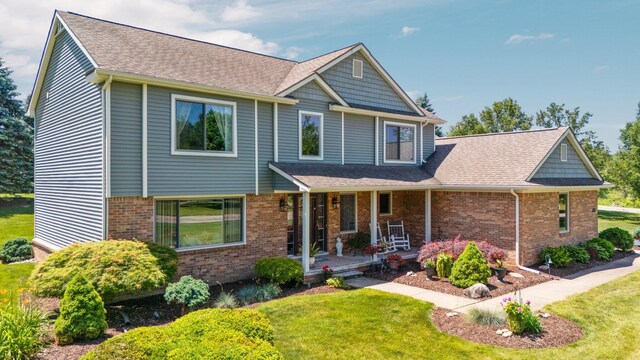 7662 Hidden Ponds Blvd, Brighton, MI 48114 - craftsman inspired home with a porch, a front yard, roof with shingles, and brick siding