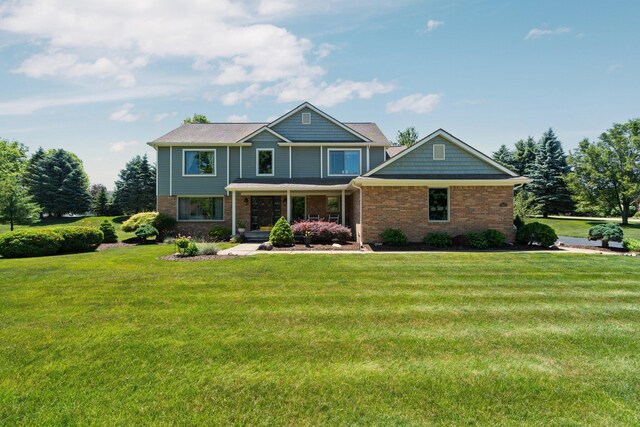7662 Hidden Ponds Blvd, Brighton, MI 48114 - craftsman-style house with brick siding, a front lawn, and a porch