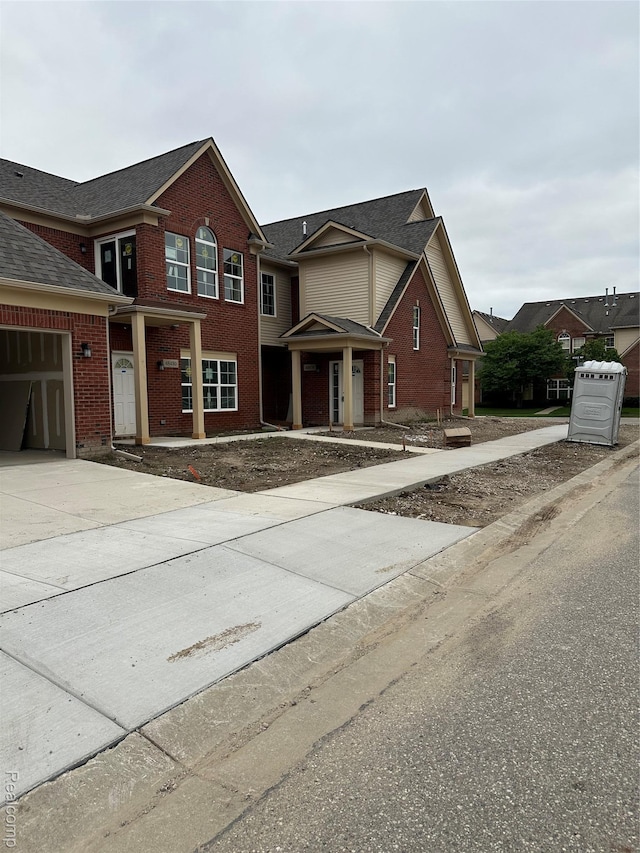 48522 Bridge Way Unit 565, Canton, MI 48188 - traditional home featuring brick siding, concrete driveway, a garage, and roof with shingles