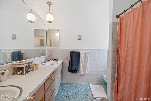 6088 Sierra Pass, Flint, MI 48532 - bathroom with tile walls, double vanity, a wainscoted wall, tile patterned floors, and a shower with curtain