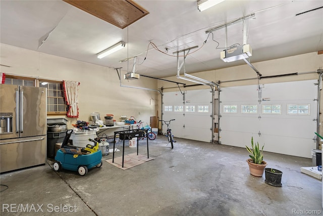 6088 Sierra Pass, Flint, MI 48532 - garage with high end fridge and a garage door opener