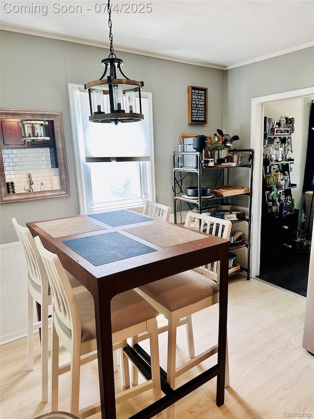 23360 Battelle Ave, Hazel Park, MI 48030 - dining room featuring light wood finished floors, a chandelier, crown molding, and a decorative wall
