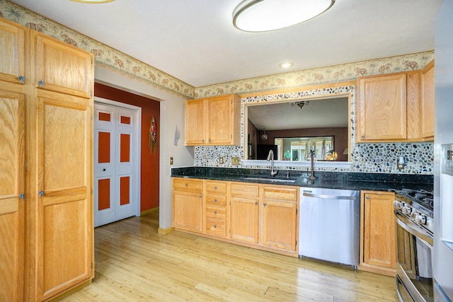 1721 Quail Run Dr, Kalamazoo, MI 49009 - kitchen featuring appliances with stainless steel finishes, light wood finished floors, backsplash, and dark stone counters