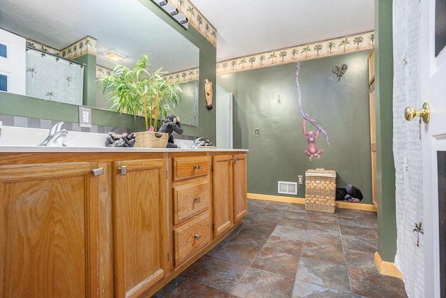 1721 Quail Run Dr, Kalamazoo, MI 49009 - bathroom featuring double vanity and stone finish flooring