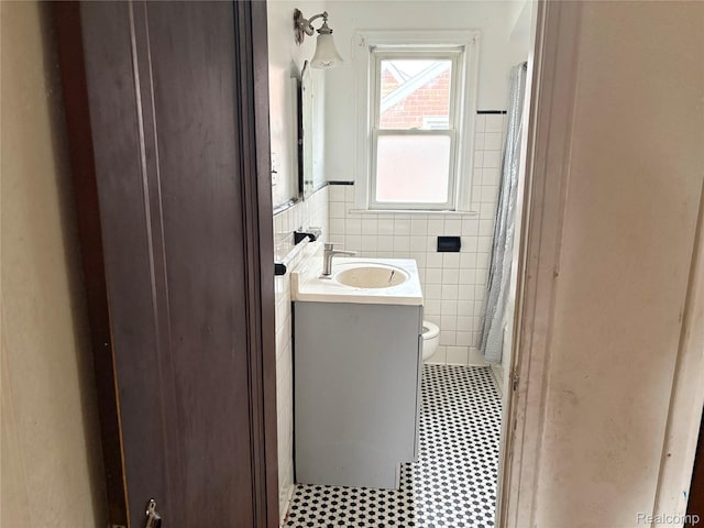 14892 Hubbell St, Detroit, MI 48227 - bathroom with tile walls, vanity, a wainscoted wall, and a shower with shower curtain