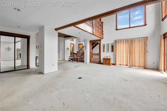 9000 Ferry Rd, Grosse Ile, MI 48138 - unfurnished living room featuring stairway and a high ceiling